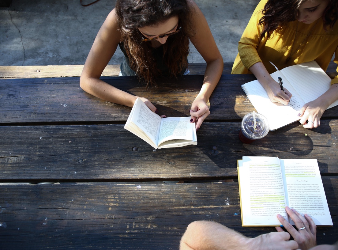 students sitting outdoors reading