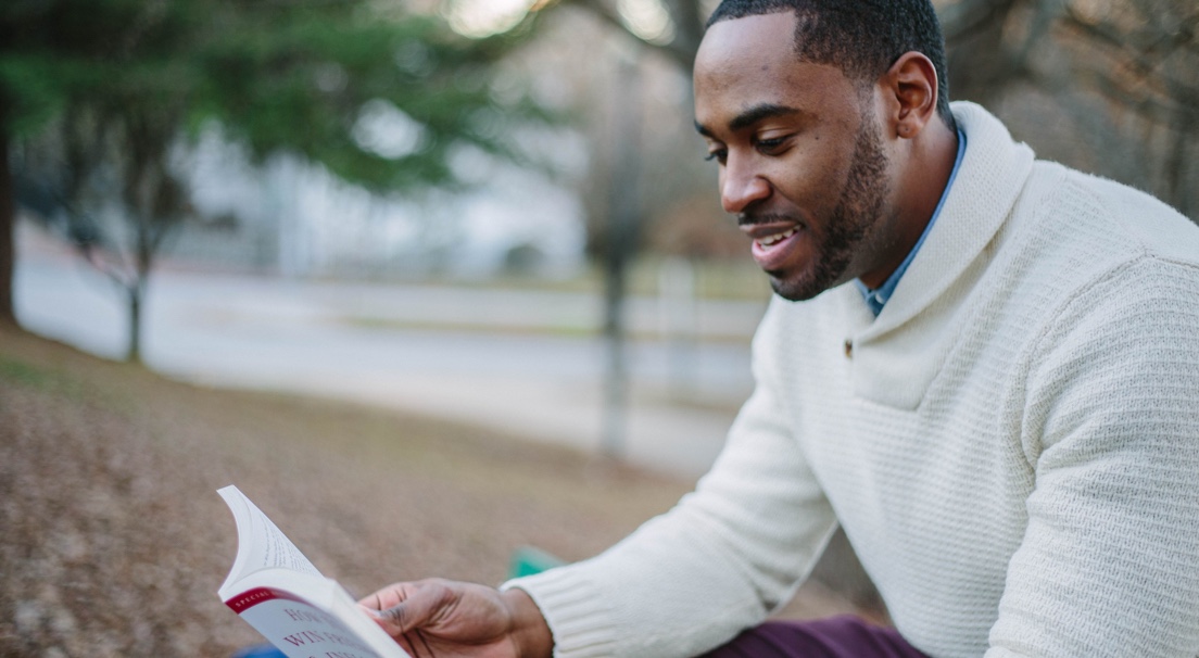 another student sitting outdoors reading